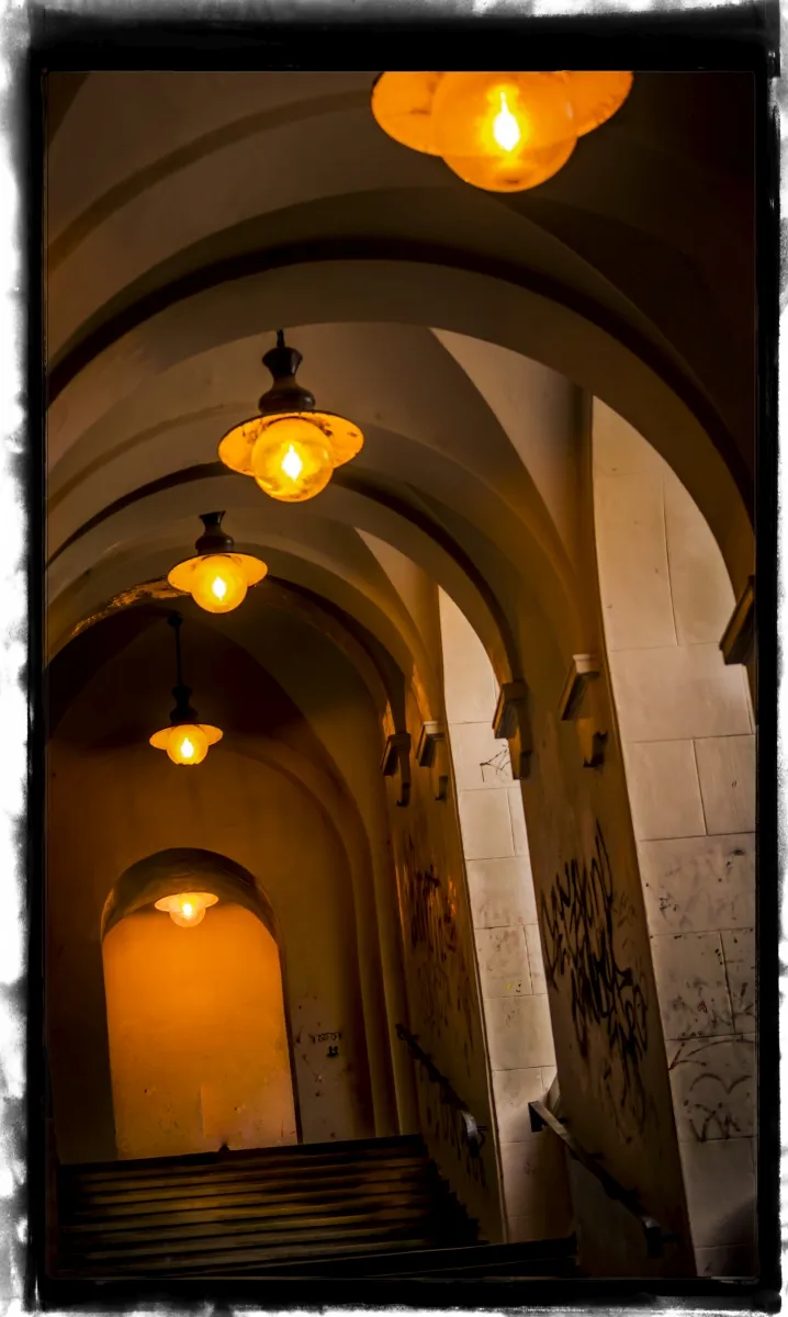 Arched stair corridor lit by hanging lamps
